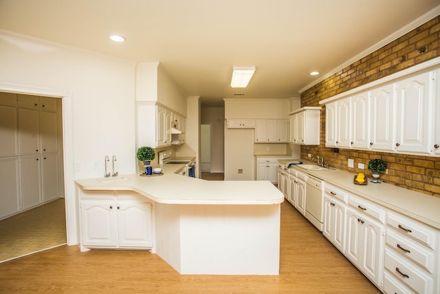 kitchen featuring white cabinetry, dishwasher, sink, kitchen peninsula, and electric stove