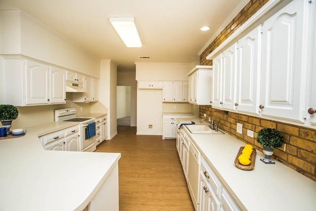 kitchen with sink, white appliances, tasteful backsplash, white cabinets, and light wood-type flooring