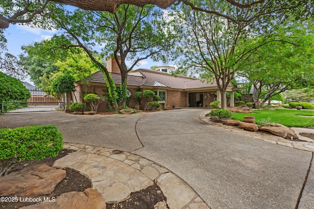 5118 2nd St, Lubbock, TX 79416 - view of front of home with a tile roof, curved driveway, a gate, and a chimney