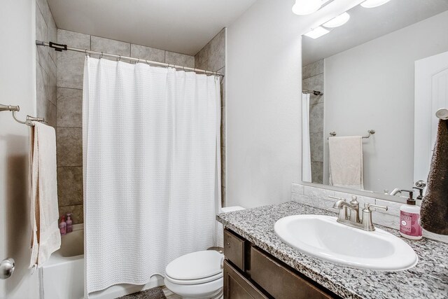 full bathroom featuring vanity, shower / tub combo, and toilet