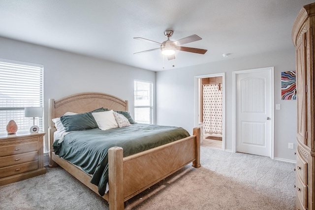 carpeted bedroom featuring ceiling fan and ensuite bathroom