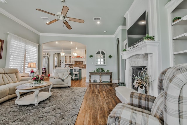 living room with ceiling fan, a healthy amount of sunlight, a premium fireplace, and hardwood / wood-style floors