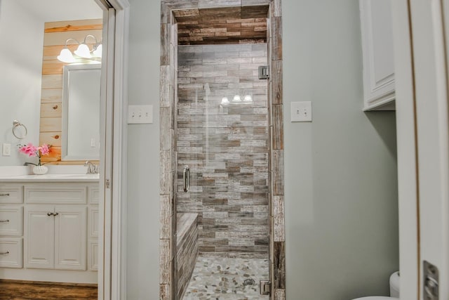 bathroom with vanity, a shower with door, and toilet