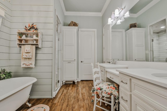 bathroom featuring vanity, hardwood / wood-style flooring, ornamental molding, and shower with separate bathtub