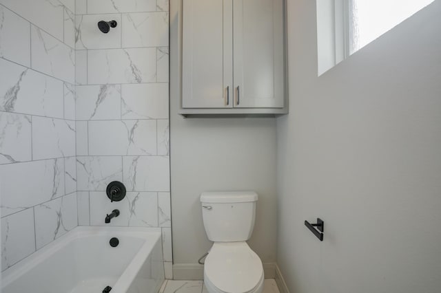 bathroom with tiled shower / bath combo and toilet