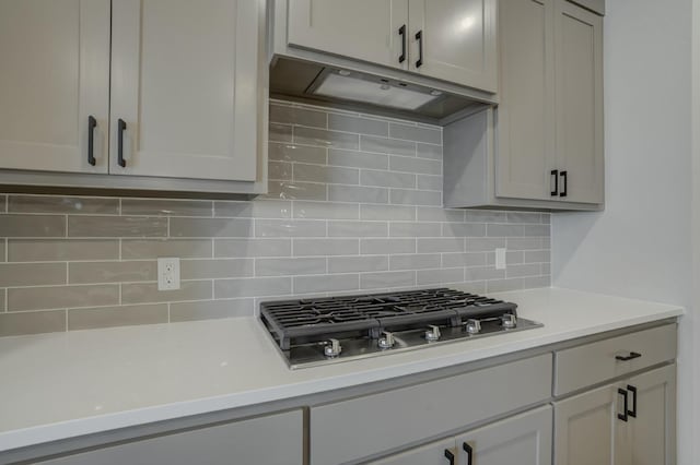 kitchen with stainless steel gas stovetop and backsplash