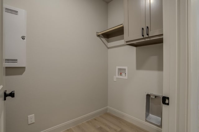 laundry room featuring cabinets, light hardwood / wood-style floors, and hookup for a washing machine