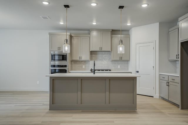 kitchen with decorative light fixtures, gray cabinets, and appliances with stainless steel finishes