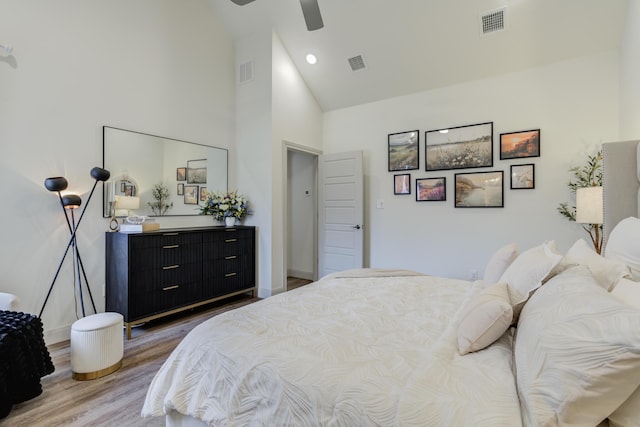 bedroom featuring visible vents, wood finished floors, and high vaulted ceiling