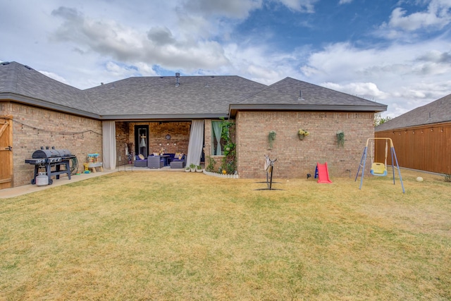 rear view of property featuring a lawn, a shingled roof, an outdoor hangout area, and brick siding