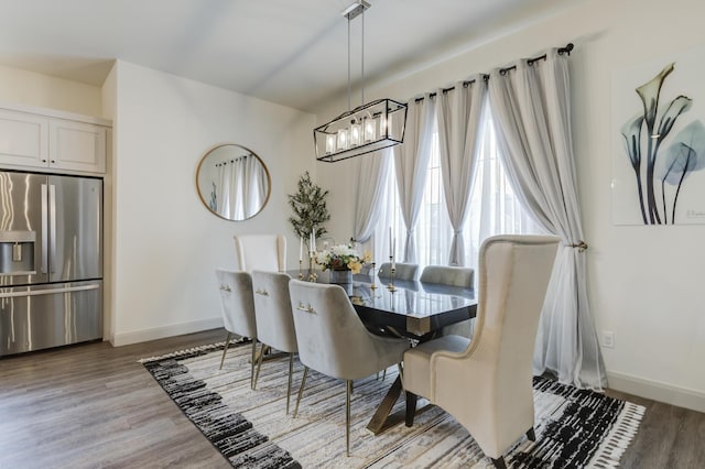 dining area with an inviting chandelier, wood finished floors, and baseboards