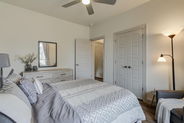 bedroom featuring baseboards, wood finished floors, a ceiling fan, and a closet