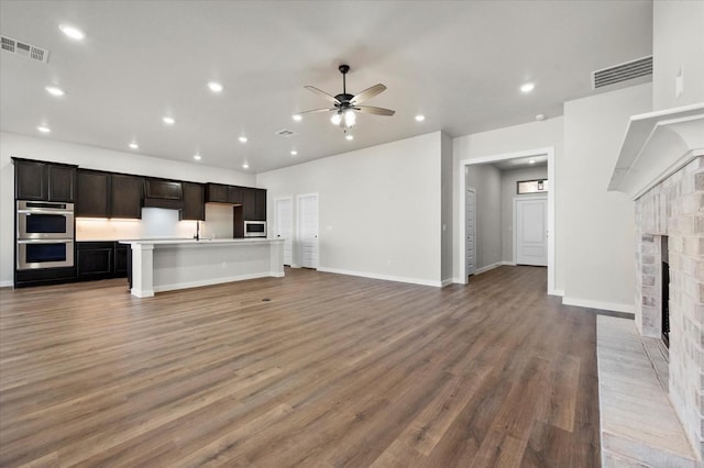 1204 E 31st St, Wolfforth, TX 79382 - unfurnished living room with hardwood / wood-style flooring, a fireplace, and ceiling fan