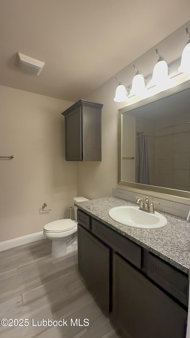 7501 100th St, Lubbock, TX 79424 - bathroom featuring vanity, wood finished floors, and a shower with curtain