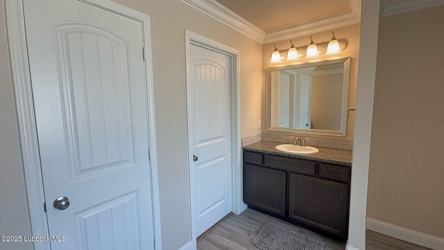 7501 100th St, Lubbock, TX 79424 - bathroom featuring crown molding, vanity, and wood finished floors