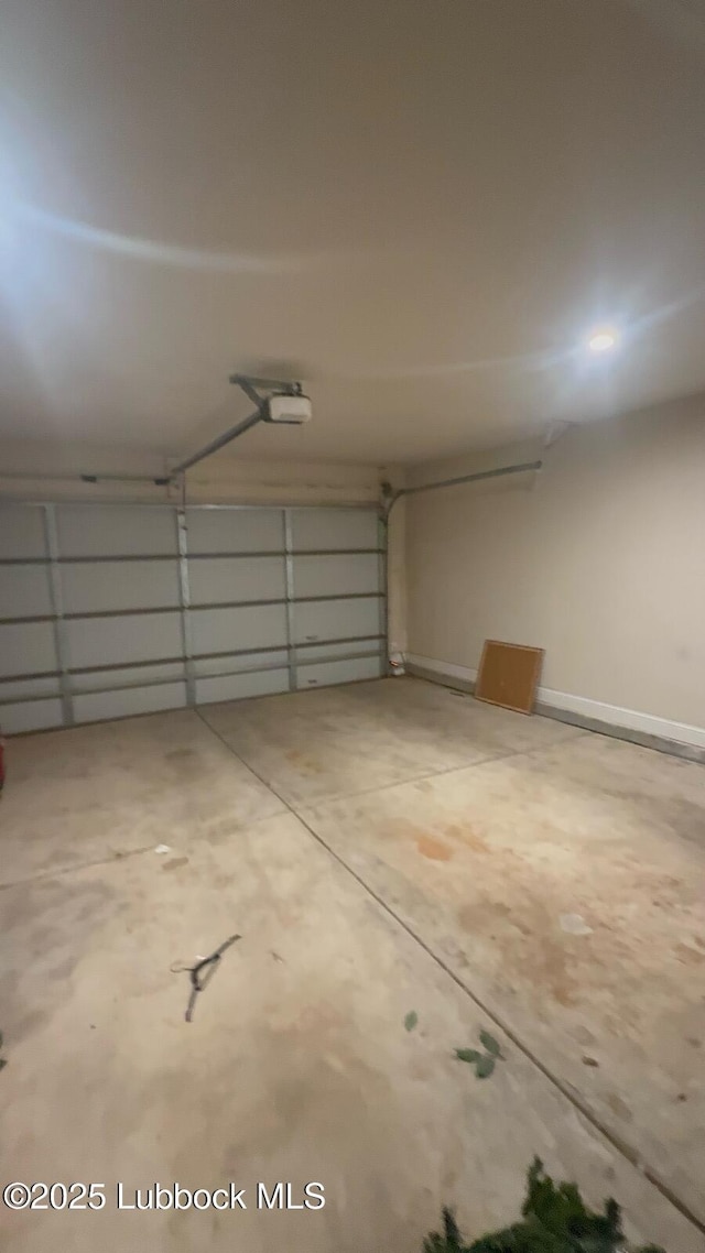 7501 100th St, Lubbock, TX 79424 - garage featuring a garage door opener and baseboards