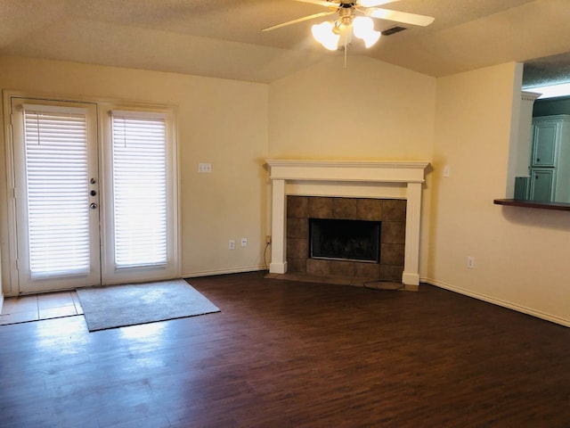 unfurnished living room featuring dark hardwood / wood-style flooring, a fireplace, vaulted ceiling, and ceiling fan