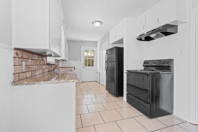 kitchen with sink, light stone countertops, black appliances, white cabinets, and light tile patterned flooring