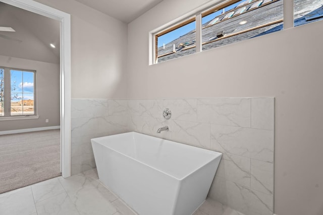 bathroom featuring a bathing tub and tile walls