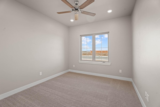 carpeted spare room featuring ceiling fan