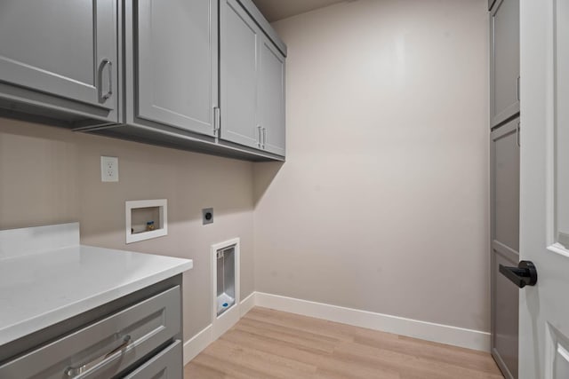 washroom featuring cabinets, washer hookup, light hardwood / wood-style flooring, and electric dryer hookup