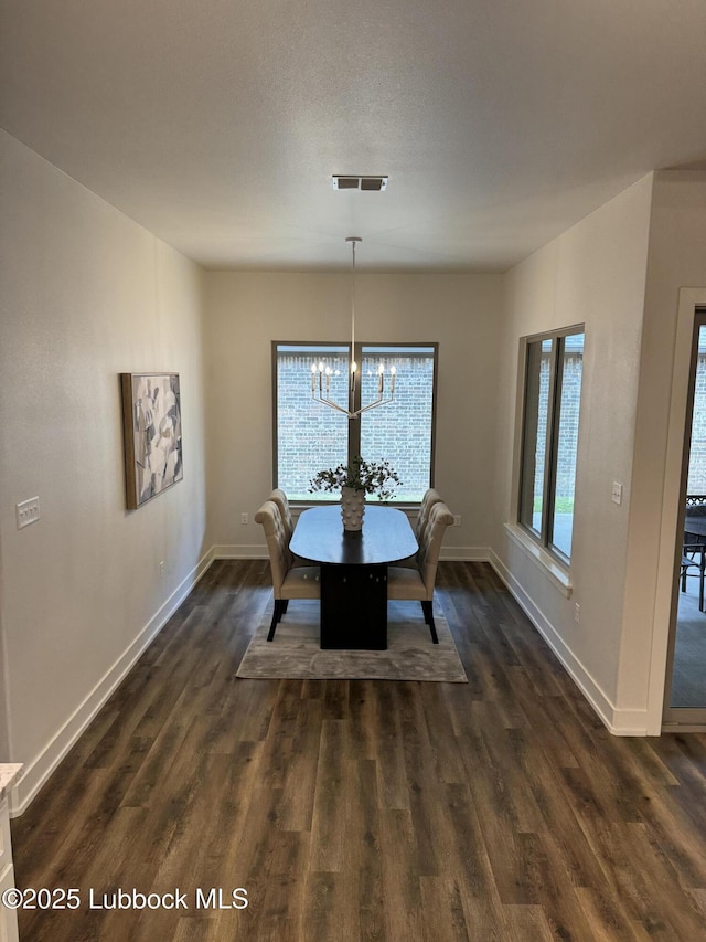 10506 Troy Ave, Lubbock, TX 79424 - dining space with baseboards, dark wood-type flooring, and a chandelier