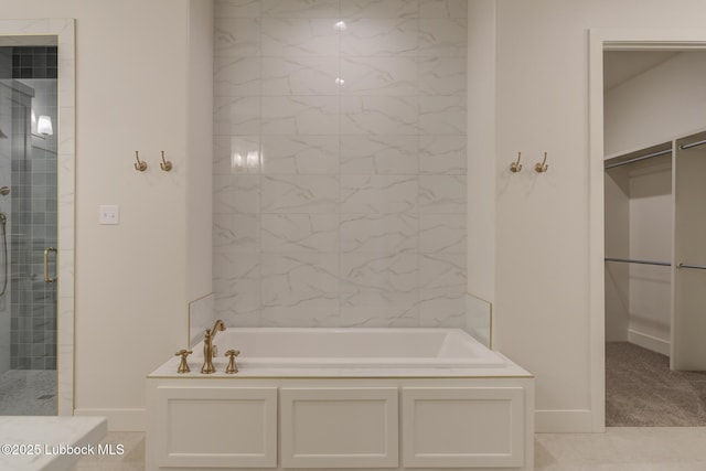 10506 Troy Ave, Lubbock, TX 79424 - full bath with a garden tub, a shower stall, a walk in closet, and baseboards