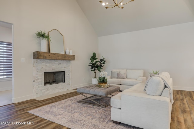 10506 Troy Ave, Lubbock, TX 79424 - living area with a chandelier, a fireplace, wood finished floors, baseboards, and high vaulted ceiling