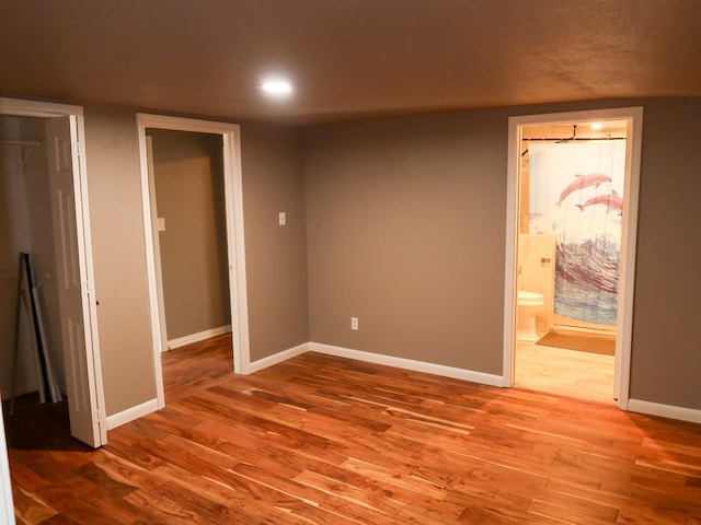 interior space with ensuite bath and wood-type flooring