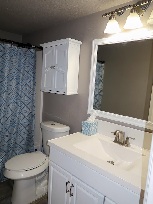 bathroom featuring vanity, curtained shower, toilet, and a textured ceiling