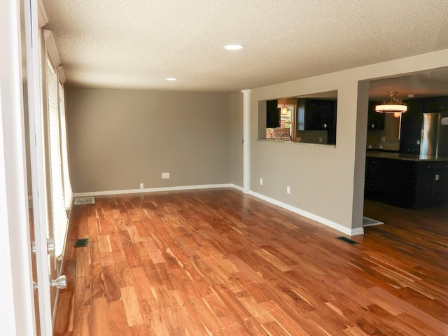 empty room featuring hardwood / wood-style flooring and a textured ceiling