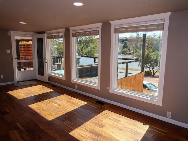 interior space with a water view and hardwood / wood-style floors