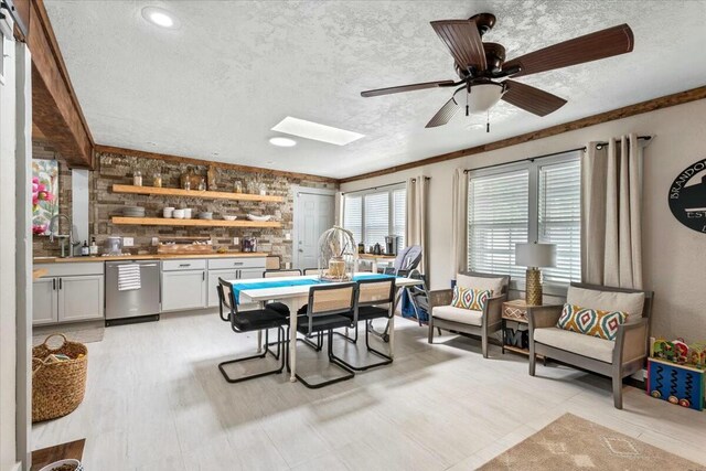 unfurnished living room with ceiling fan, brick wall, a barn door, and a textured ceiling