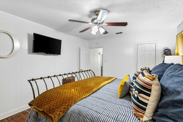 unfurnished bedroom featuring crown molding, a textured ceiling, a barn door, dark hardwood / wood-style flooring, and a closet