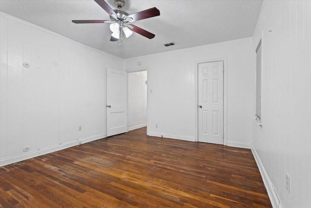 unfurnished bedroom with ceiling fan, crown molding, dark wood-type flooring, and a textured ceiling