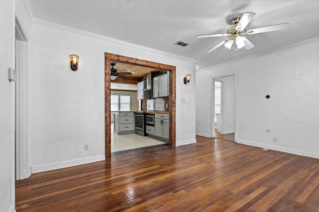 unfurnished living room featuring ceiling fan, dark wood-type flooring, ornamental molding, and a textured ceiling