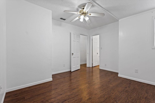 unfurnished bedroom featuring dark wood-type flooring, ceiling fan, and a textured ceiling