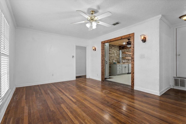 spare room with ornamental molding, dark wood-type flooring, and a textured ceiling