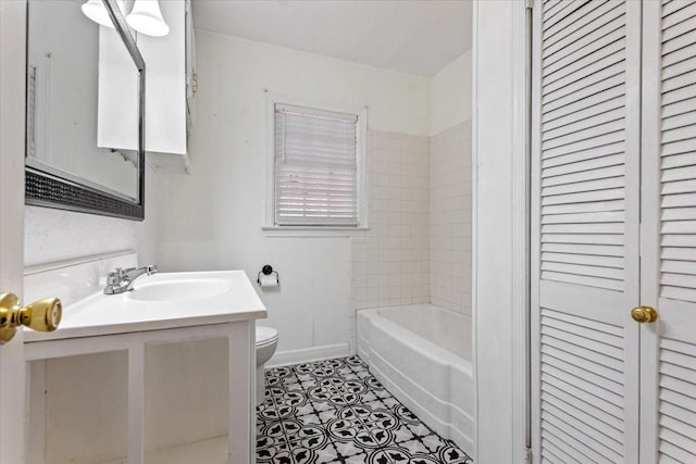 full bathroom with tile patterned flooring, vanity, tiled shower / bath, and toilet