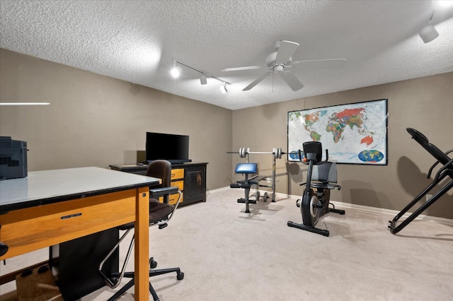 carpeted office featuring rail lighting, ceiling fan, and a textured ceiling