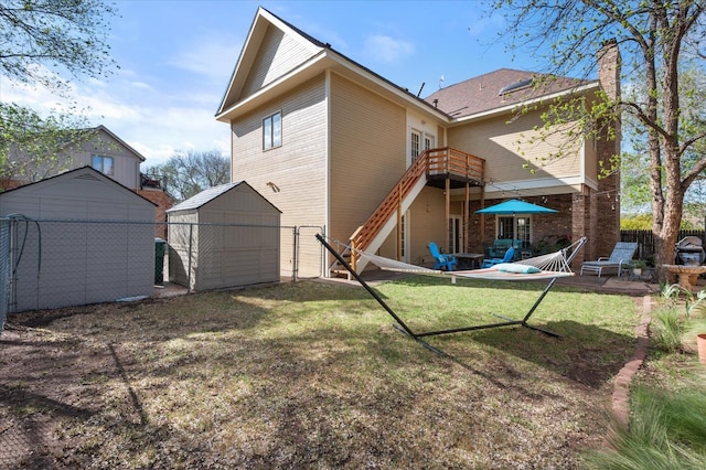 back of property with a storage shed, a yard, and a patio area