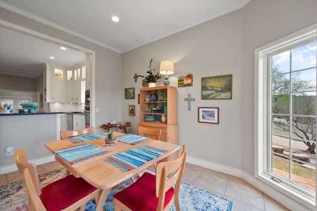 tiled dining room featuring ornamental molding