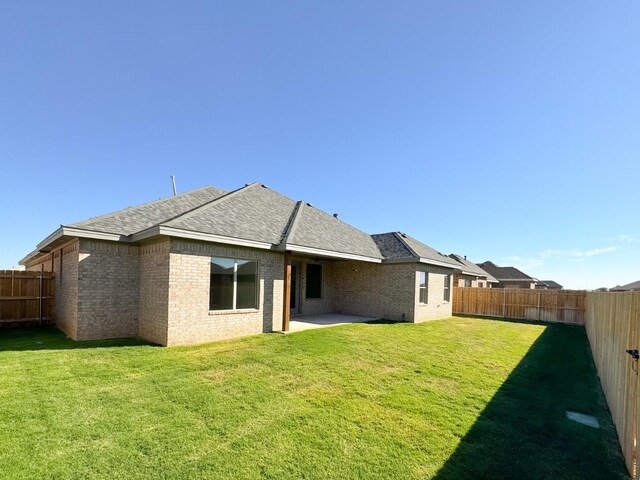 back of house featuring a lawn and a patio