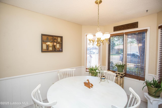 5008 59th St, Lubbock, TX 79414 - dining area featuring wainscoting, a decorative wall, a chandelier, and a textured ceiling