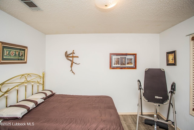 5008 59th St, Lubbock, TX 79414 - bedroom with wood finished floors and a textured ceiling