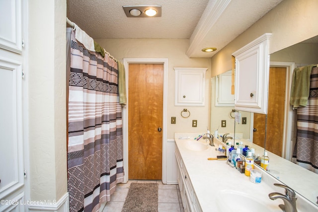5008 59th St, Lubbock, TX 79414 - bathroom with double vanity, tile patterned flooring, a textured ceiling, and curtained shower