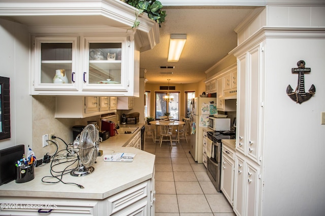 5008 59th St, Lubbock, TX 79414 - kitchen featuring white appliances, light countertops, light tile patterned floors, under cabinet range hood, and glass insert cabinets