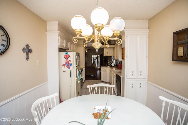5008 59th St, Lubbock, TX 79414 - dining room featuring a wainscoted wall, a chandelier, and tile patterned flooring