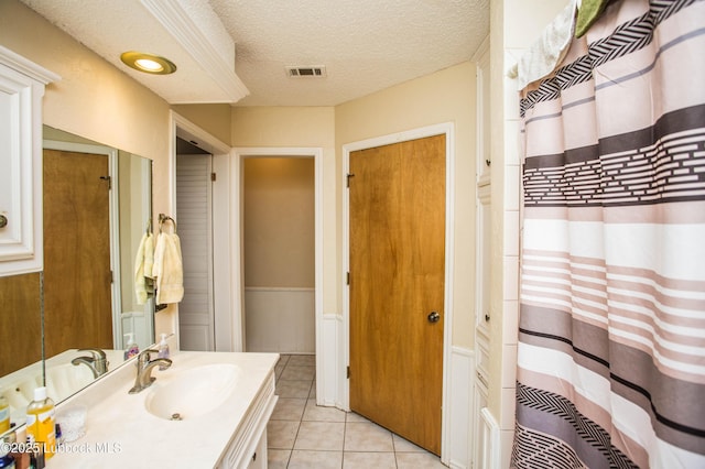 5008 59th St, Lubbock, TX 79414 - full bath with vanity, tile patterned floors, a textured ceiling, and a shower with shower curtain