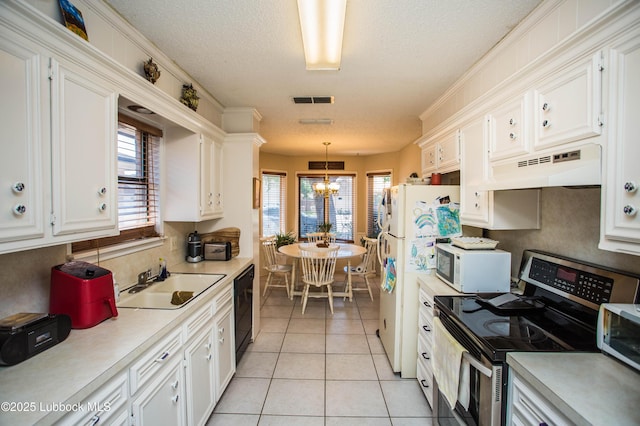 5008 59th St, Lubbock, TX 79414 - kitchen featuring electric stove, under cabinet range hood, white microwave, light countertops, and a textured ceiling